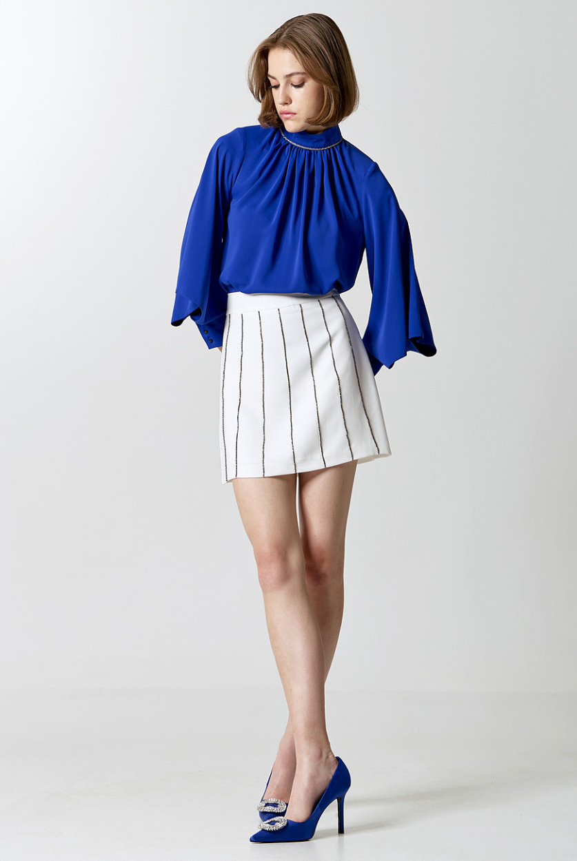 Access Fashion cobalt blue wide sleeve blouse styled with white mini skirt, full outfit.