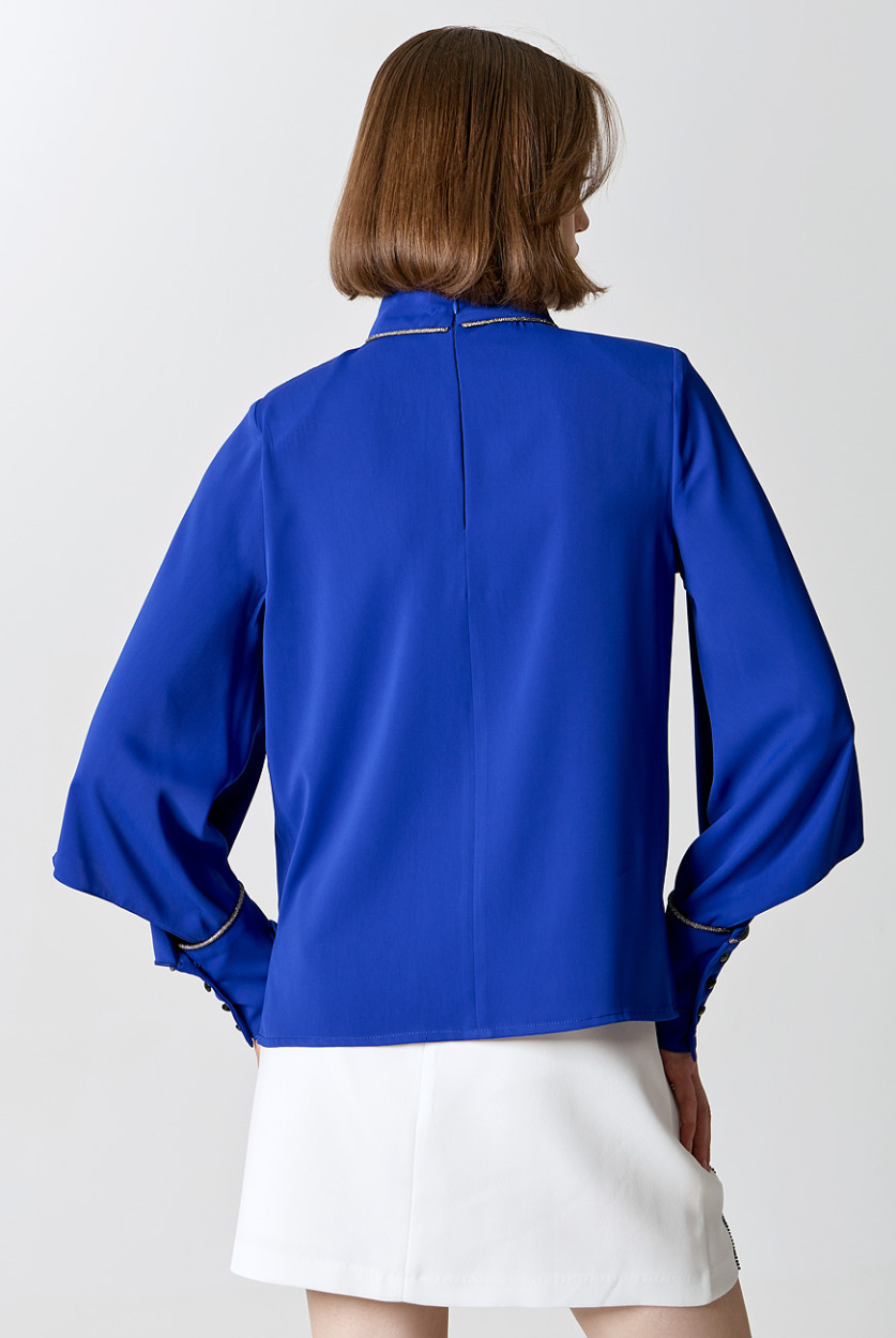 Back view of Access Fashion cobalt blue blouse with flowing sleeves and high neck trim.