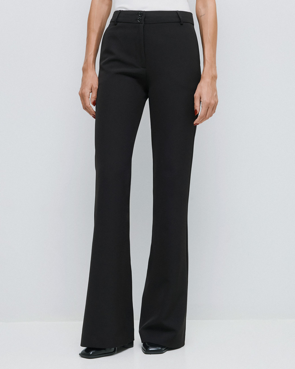Access Fashion high waisted black flared trousers styled with white top.