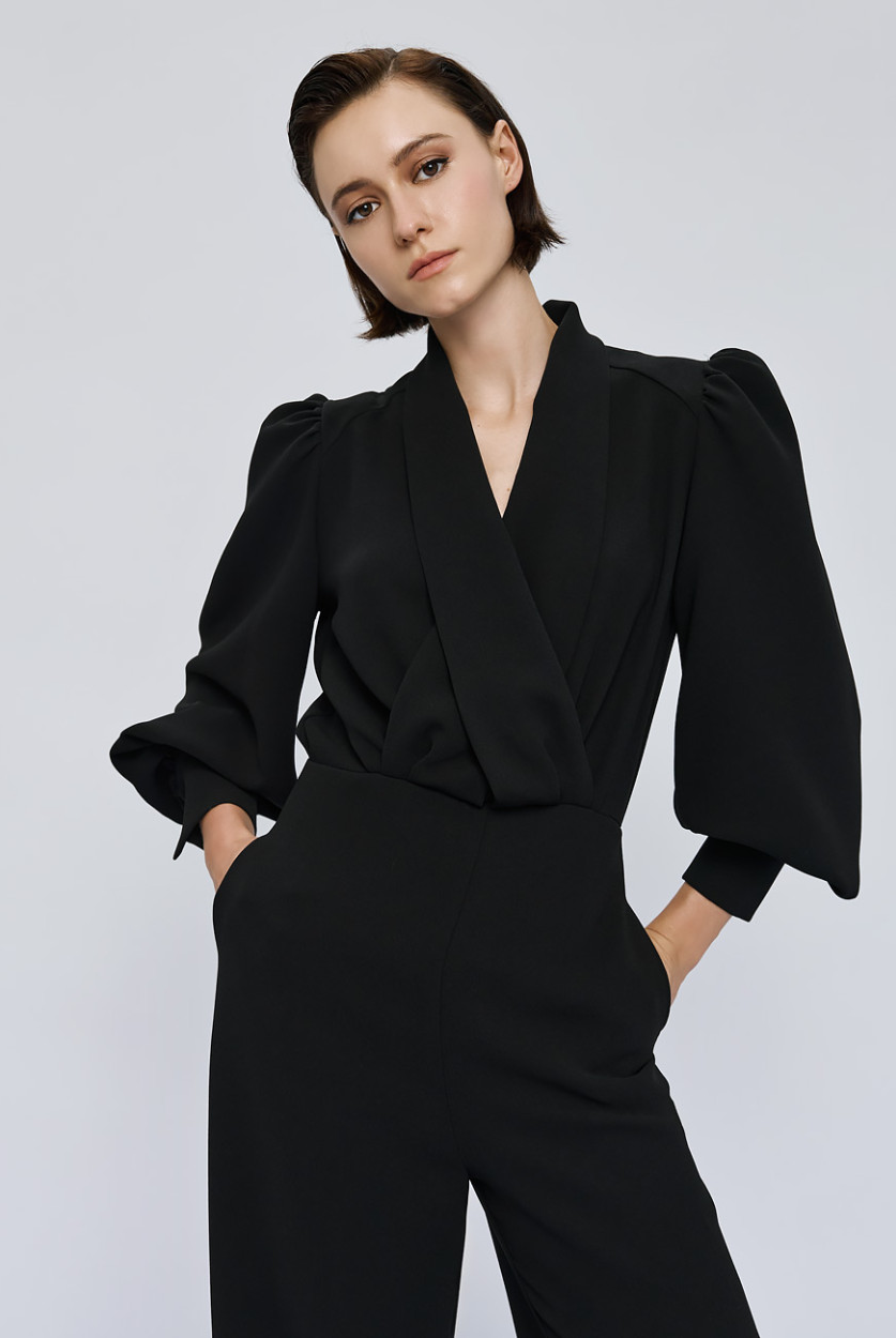 Access Fashion Black Puff Sleeve Jumpsuit three quarter front view showing wrap bodice and pockets.