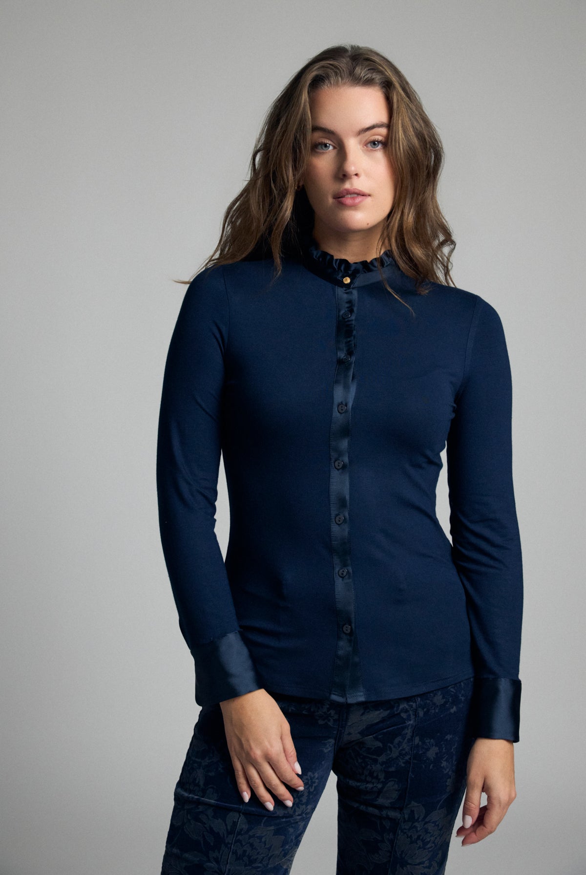 Bariloche Andria navy stretch jersey shirt – front model view showing satin trim and frill collar