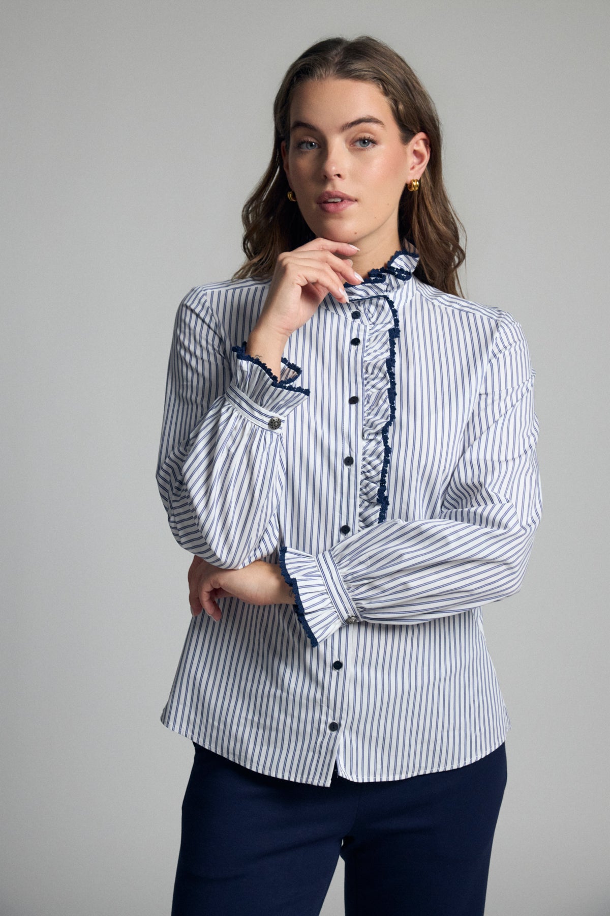 Bariloche Atina navy and white striped cotton shirt with frilled stand collar, contrast buttons and long sleeves – front model view.