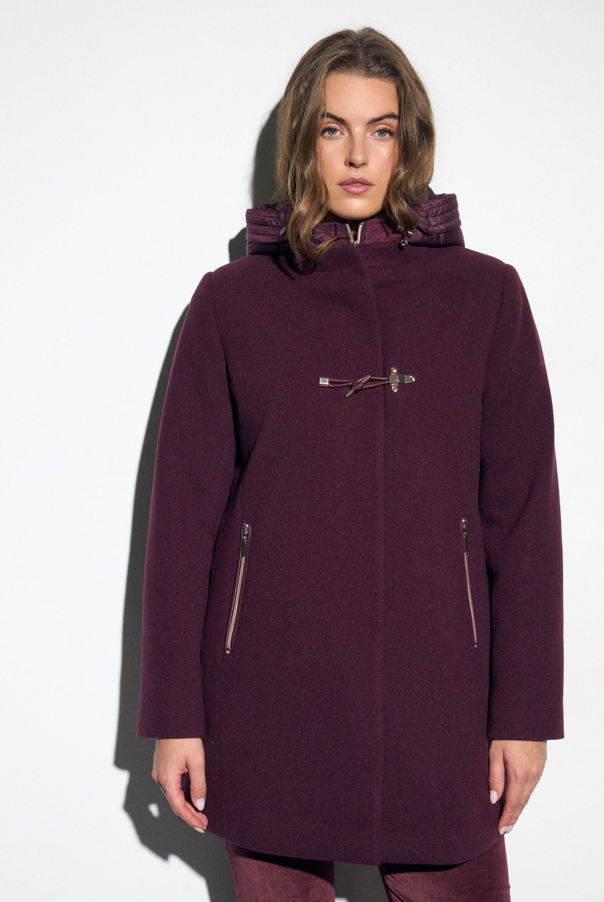 Bariloche Gata burgundy hooded duffle-style coat with quilted inner hood, decorative toggle and zipped pockets – front model view.
