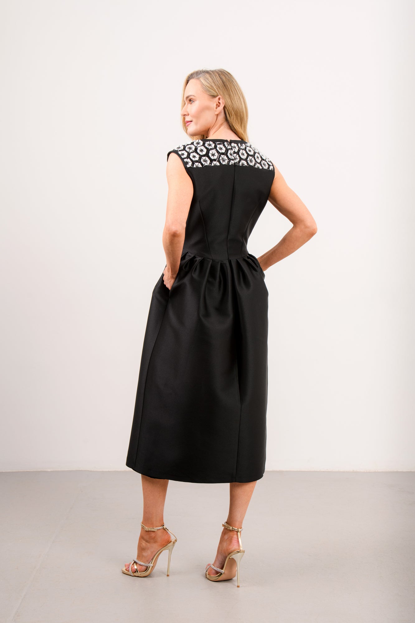 Back view of Caroline Kilkenny Jenny black satin midi dress with embroidered yoke