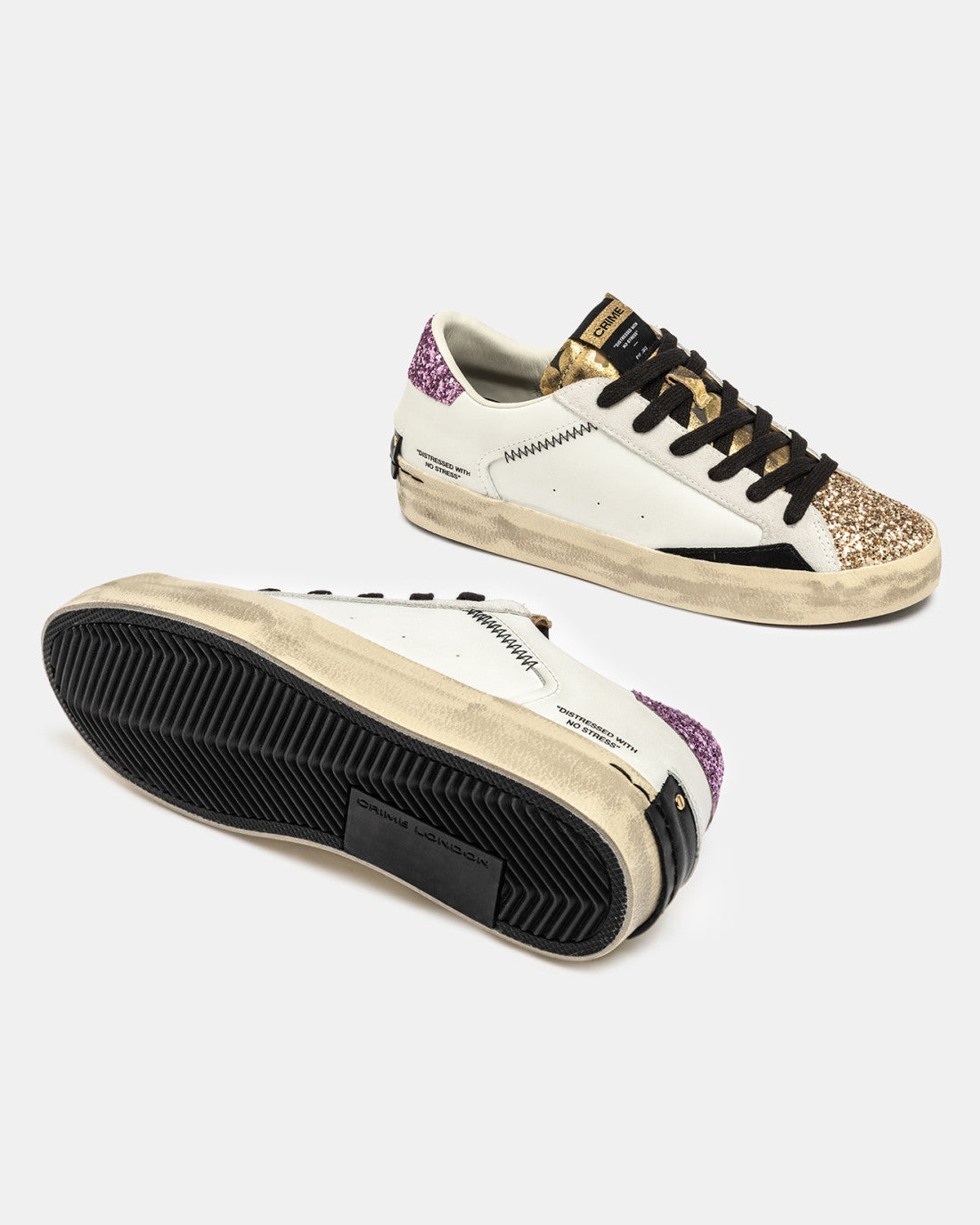 Crime London distressed gold glitter trainers shown from underneath with black sole