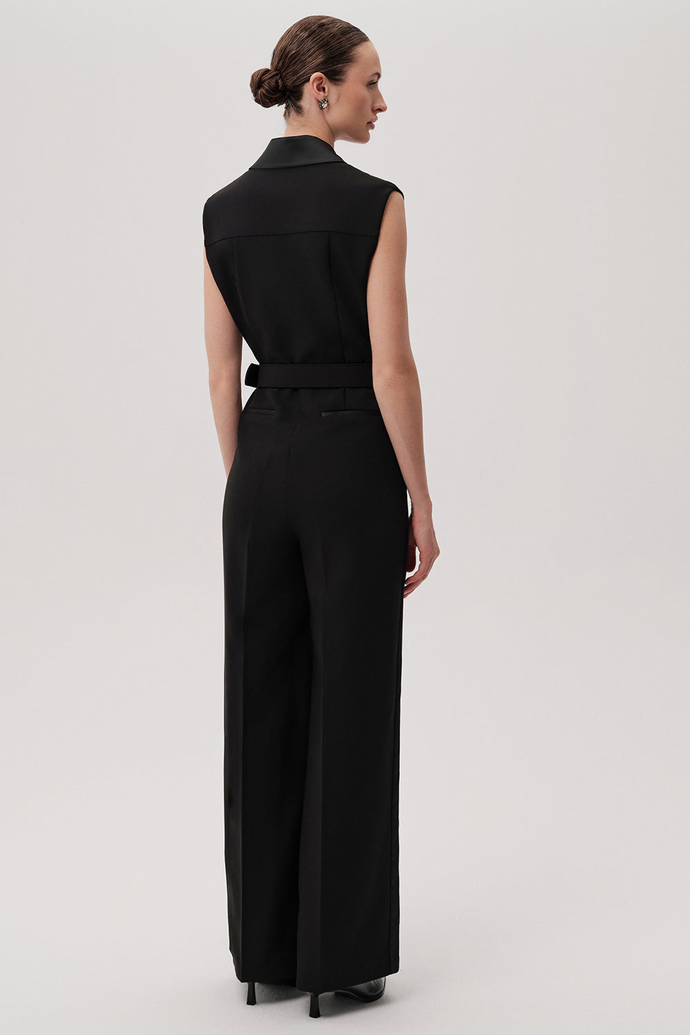 Back view of Exquise Onyx wide-leg black tailored jumpsuit with waist belt