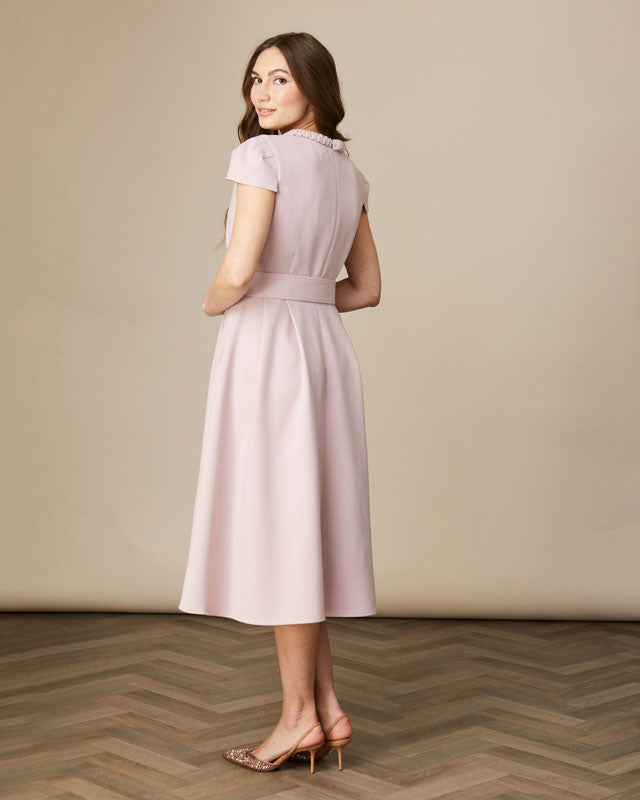 Back view of blush Charlotte swing dress showing belt and A-line silhouette.