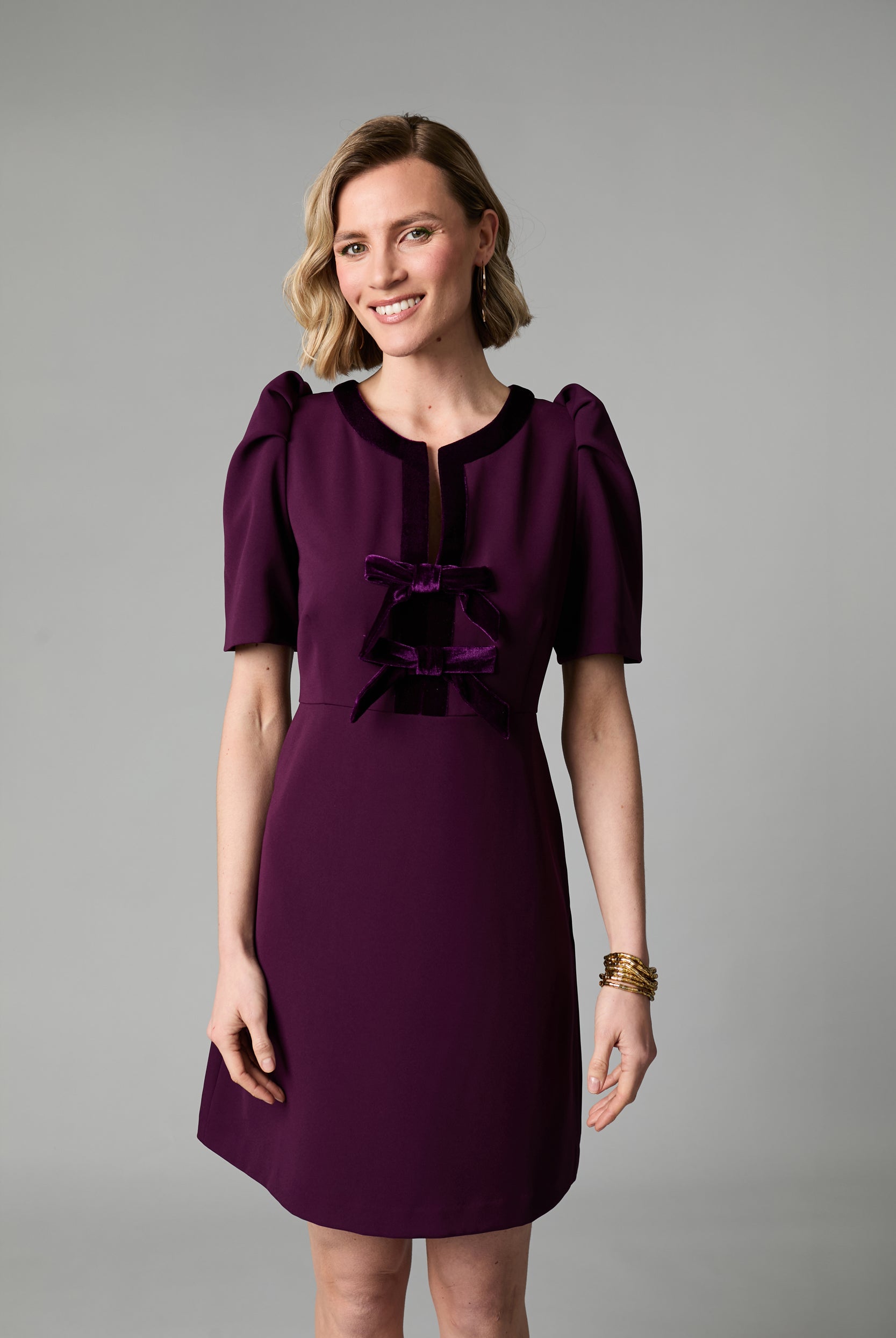 Front view of Fee G Sara plum mini occasion dress with velvet bows