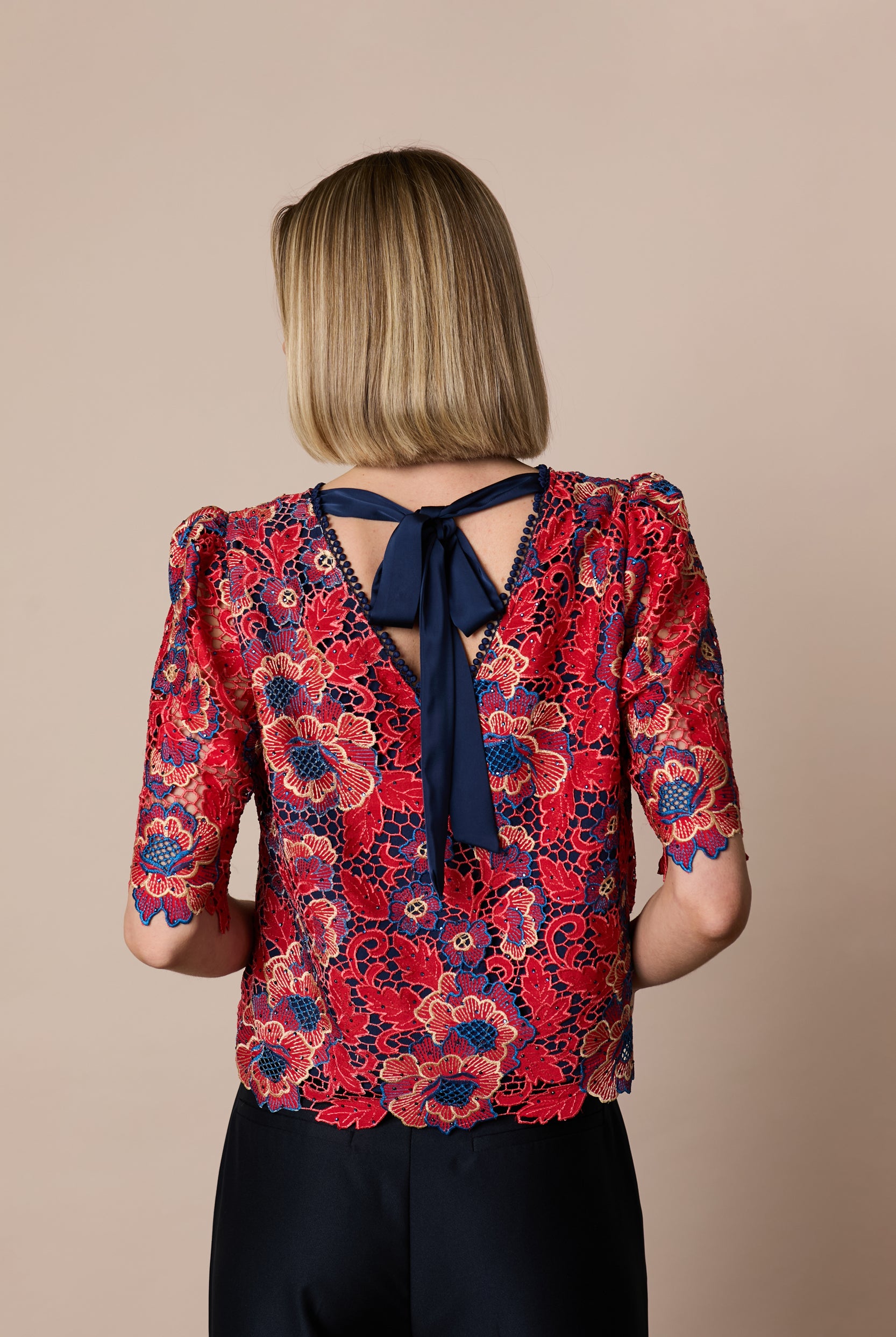 Back view of Fee G Lori floral lace top with navy statement bow