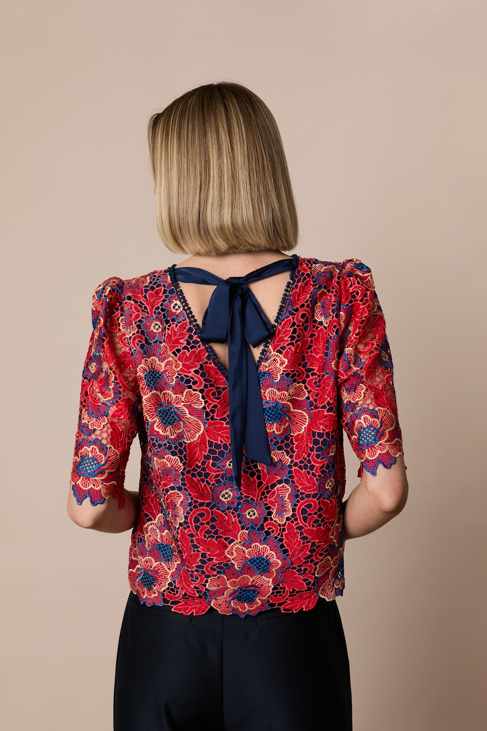 Back view of Fee G Lori floral lace top with navy statement bow
