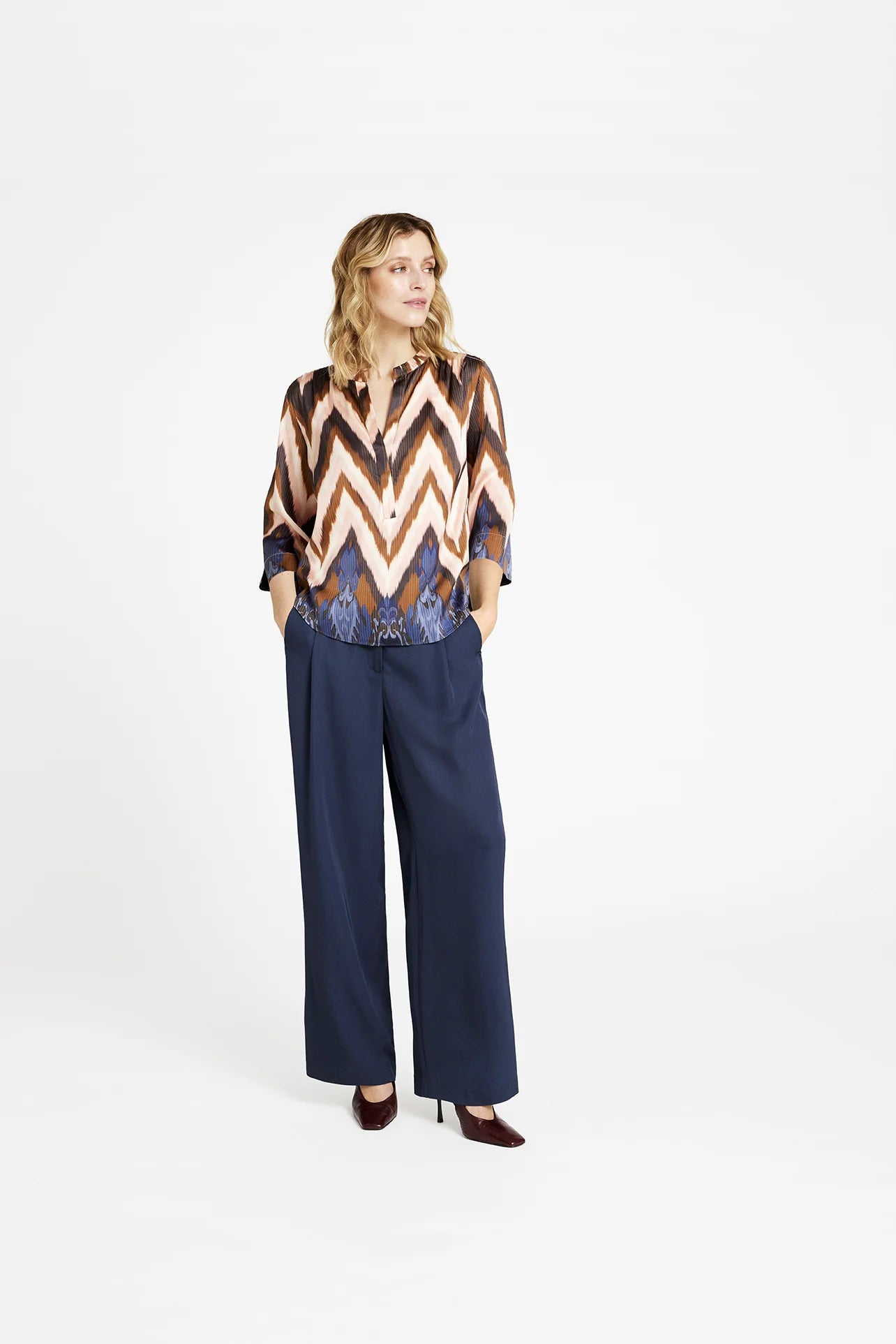 Model wearing Gustav Sikka blouse with zig zag print in cream, blush and navy