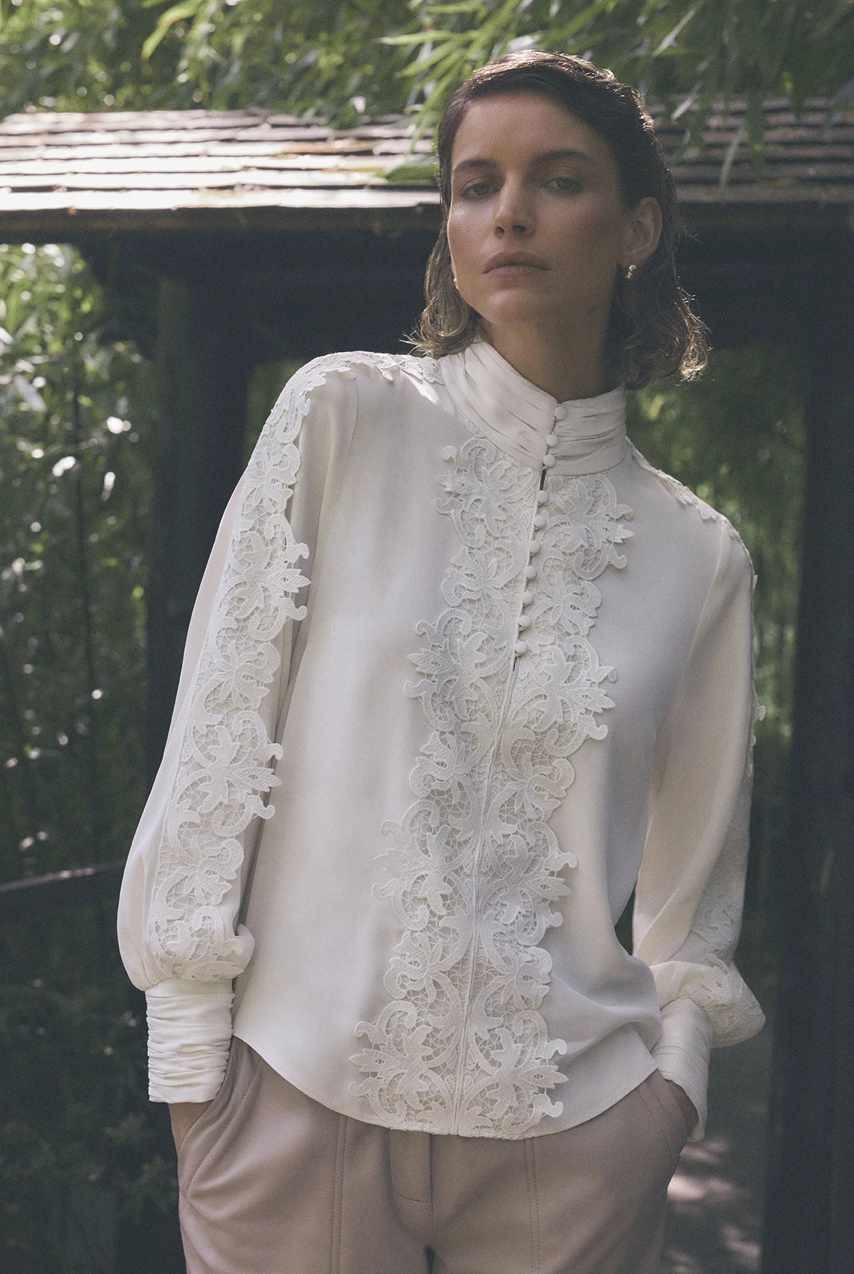 Gustav Cana off-white lace embellished blouse worn by model, showing delicate lace across the front and sleeves