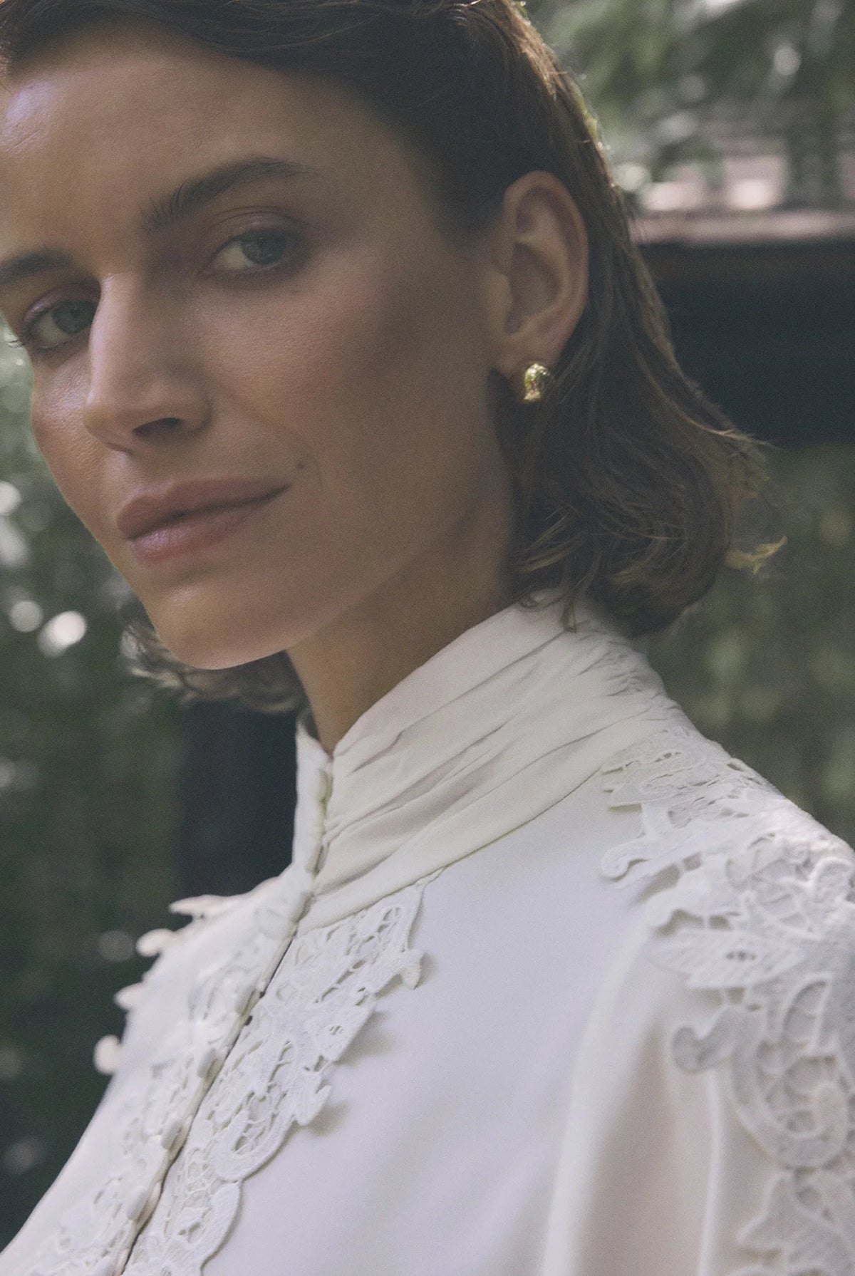 Close-up of Gustav Cana off-white blouse showing intricate lace and gathered neckline