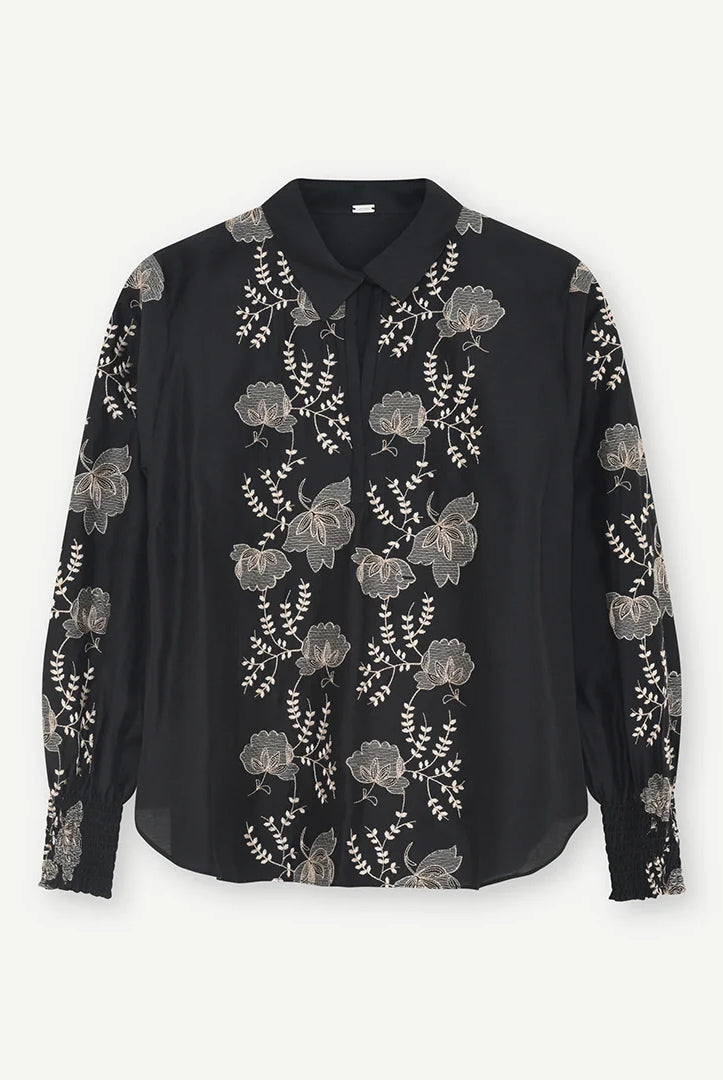 Gustav Bayanna black blouse with intricate ivory floral embroidery, classic collar and long sleeves – front view.