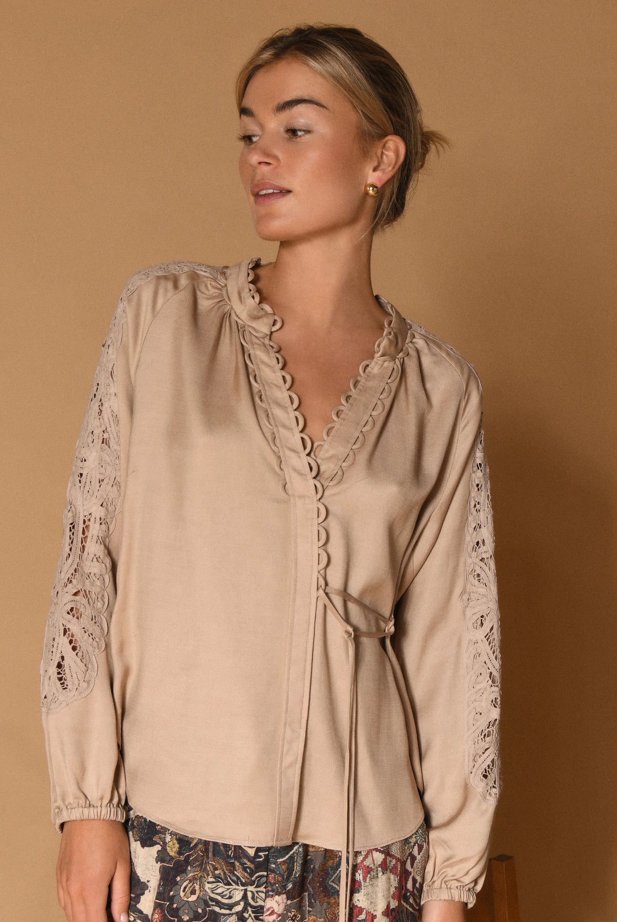 Gustav Phia Sand Stone blouse – model view showing lace sleeves and side tie