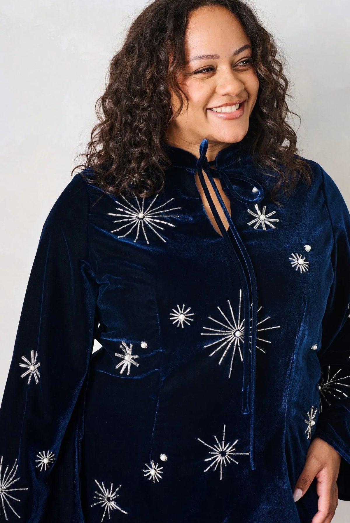 Close-up of Hope & Ivy Orelia embellished velvet dress showing tie neckline and silver star detailing.