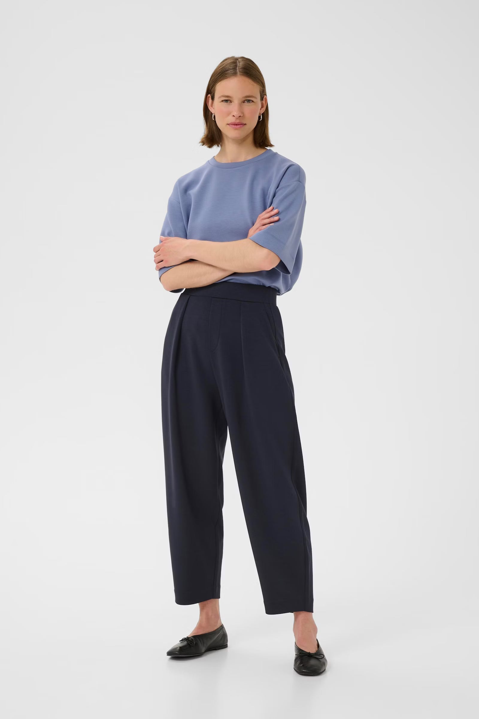 Model in InWear PannieI navy trousers with folded arms and light blue top