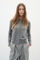 Model with hands in pockets wearing grey InWear cardigan buttoned up