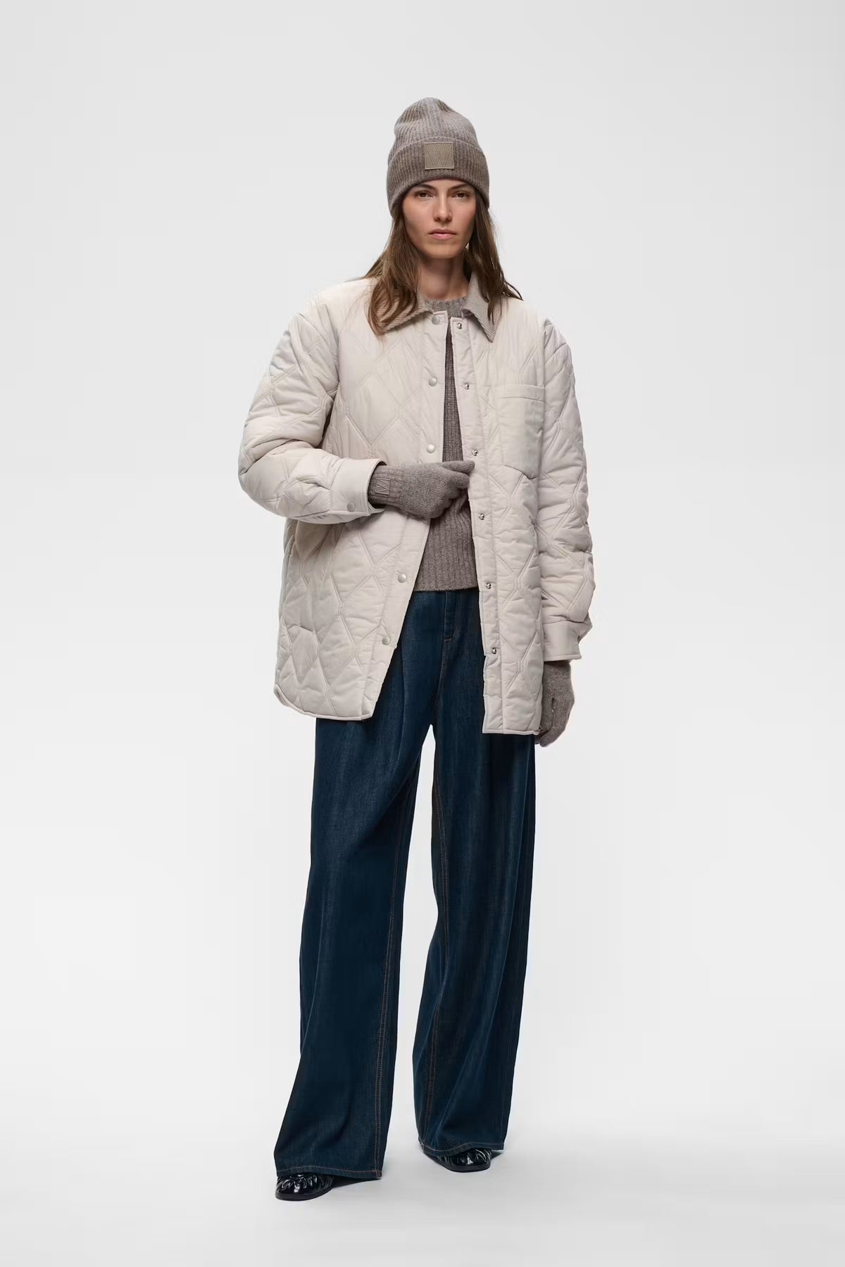 InWear Kaxy Cinder Melange beanie styled with cream quilted jacket – full model view