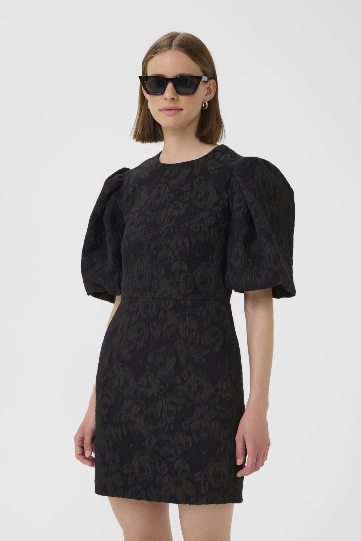 Three-quarter view of model in InWear brocade mini dress with sculptural statement puff sleeves