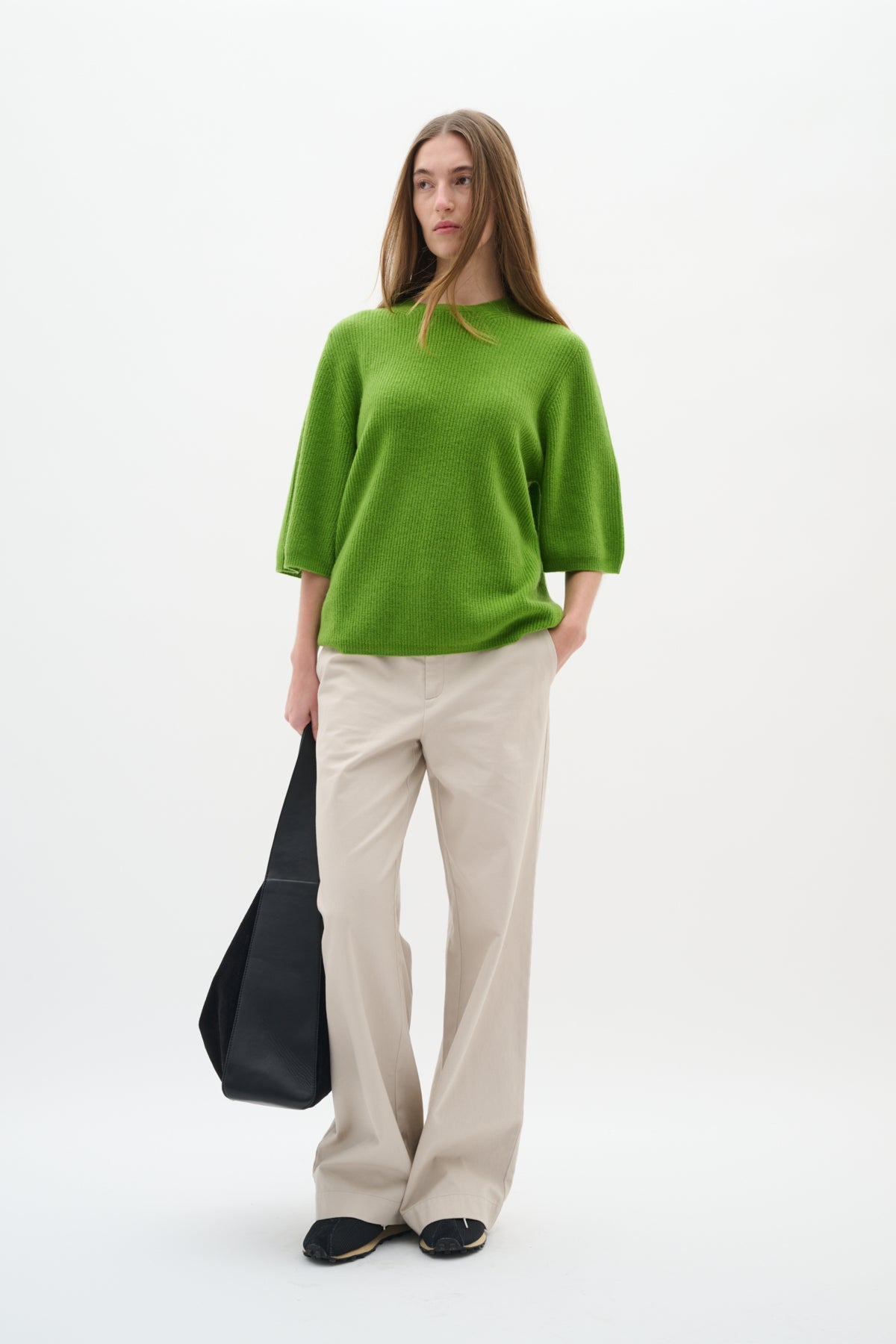 Model facing forward in InWear Bryelle beige trousers with relaxed bootcut silhouette