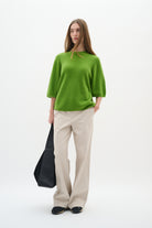 Model facing forward in InWear Bryelle beige trousers with relaxed bootcut silhouette
