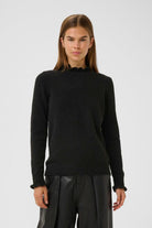 Model wearing cream InWear Anaja frill detail high neck black jumper with blue jeans.