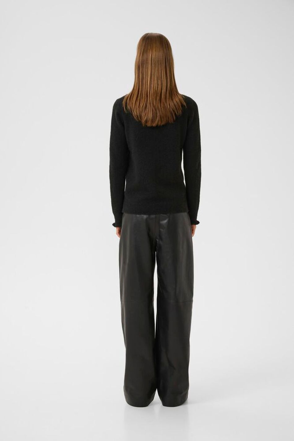 Back view of black InWear Anaja black turtleneck jumper with frill neckline and cuffs.