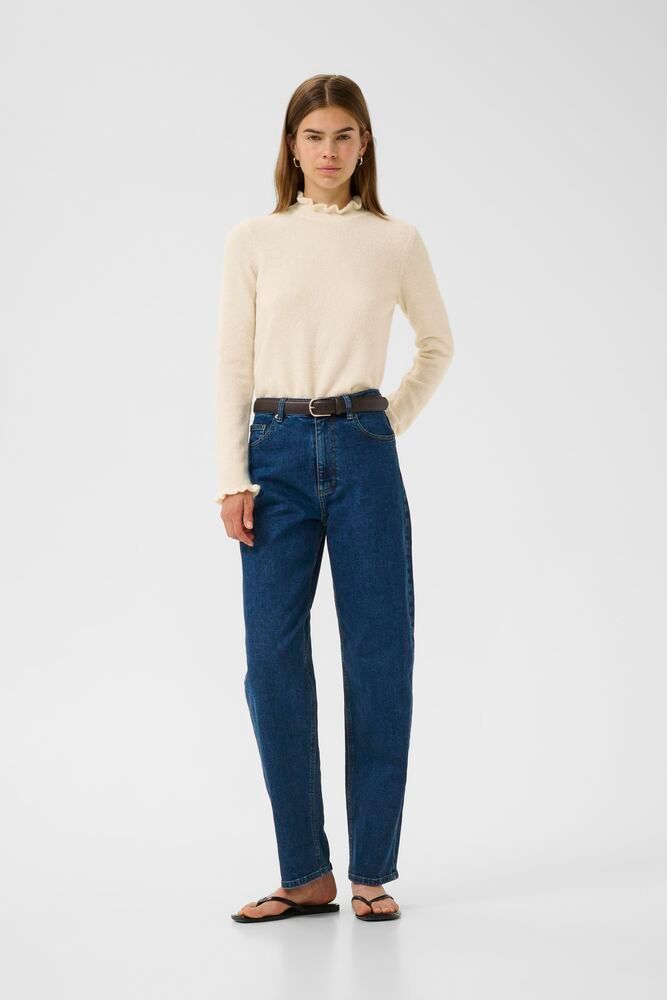 Model wearing cream InWear Anaja frill high neck jumper styled with jeans.