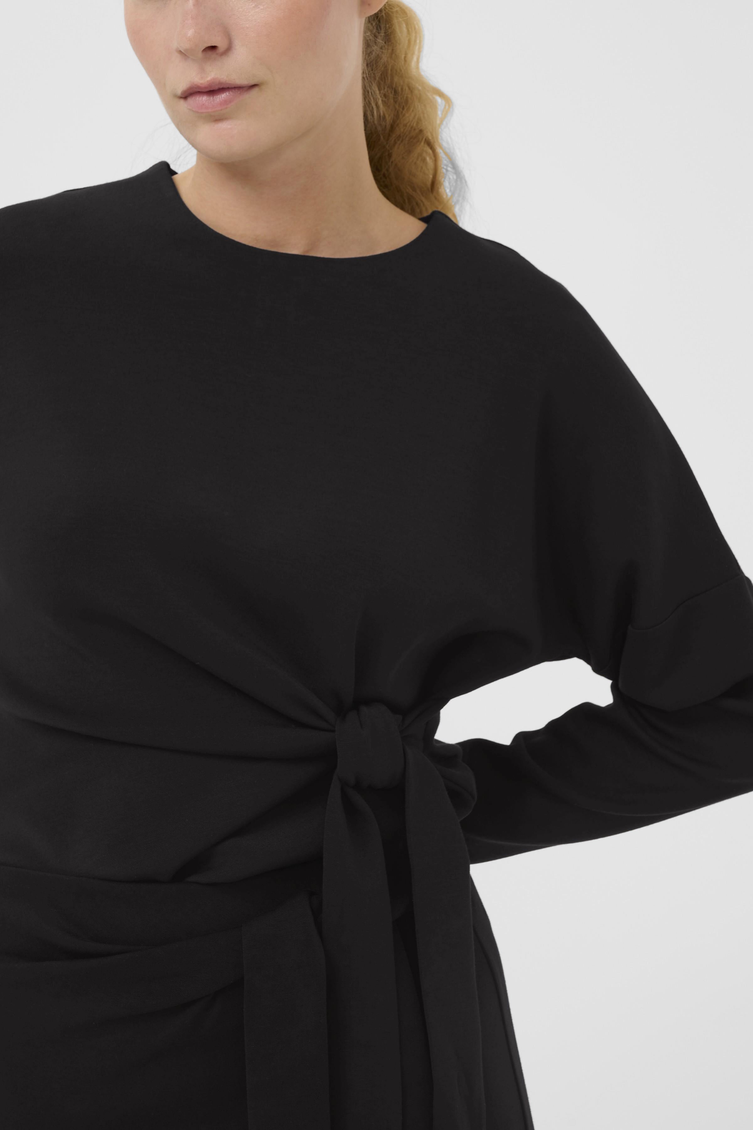 Side view of InWear Tricenti black top showing flattering tummy hiding gathered knot detail