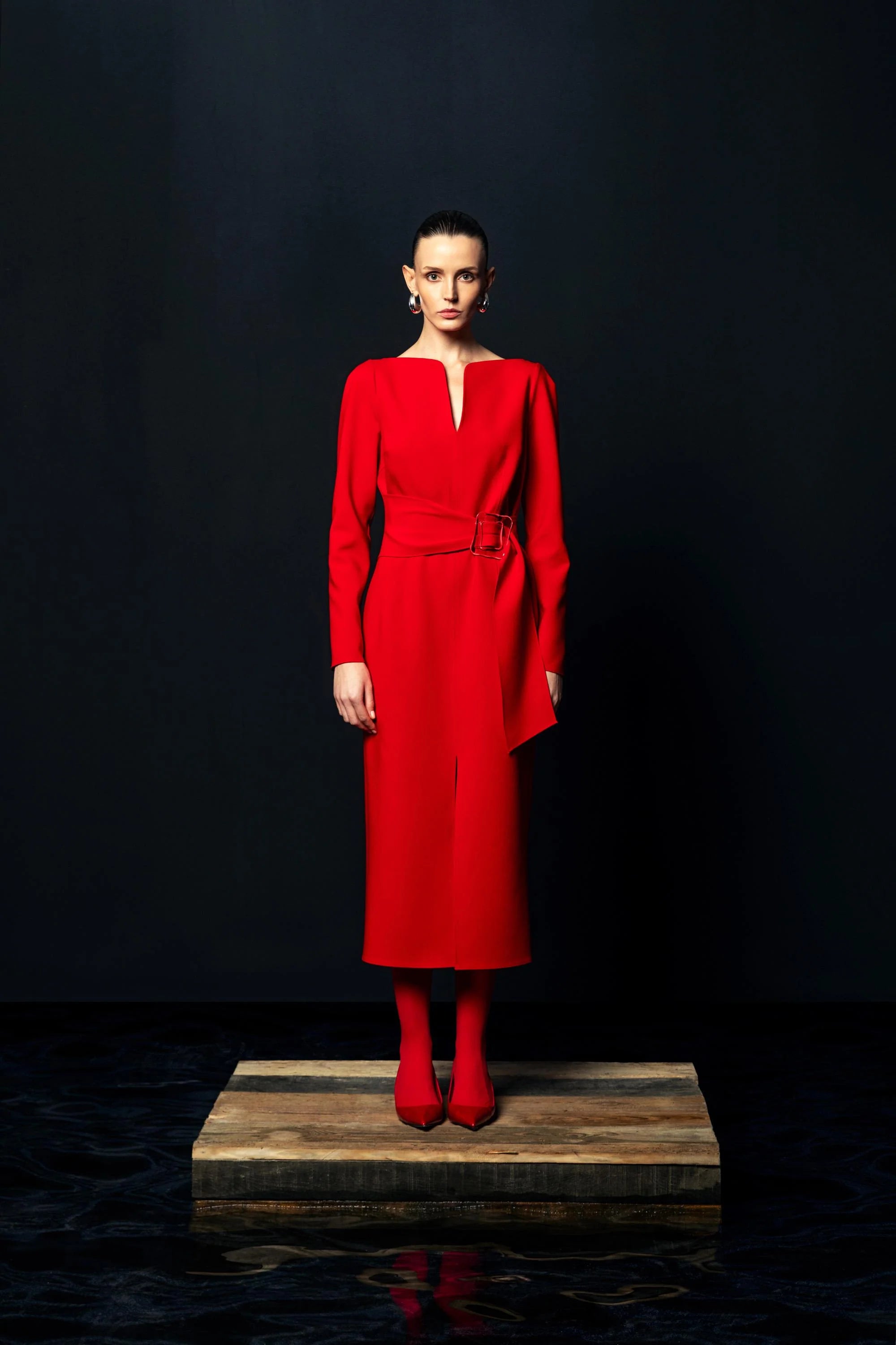 Full-length front view of Kameya red belted slit neckline dress on model