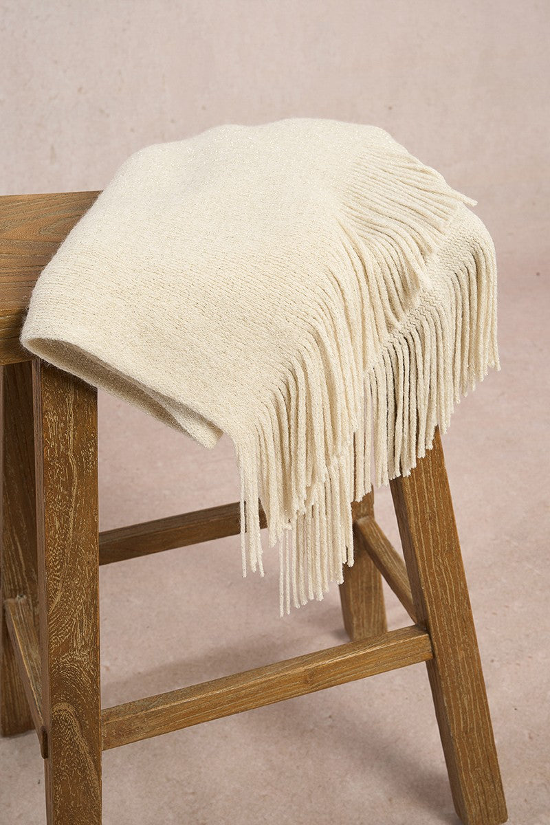 Molly Bracken cream knitted winter scarf draped on wooden stool