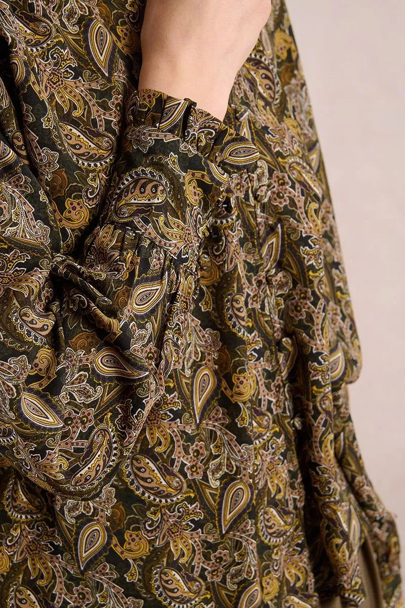 Close-up of paisley print fabric and frilled cuff detail on khaki blouse