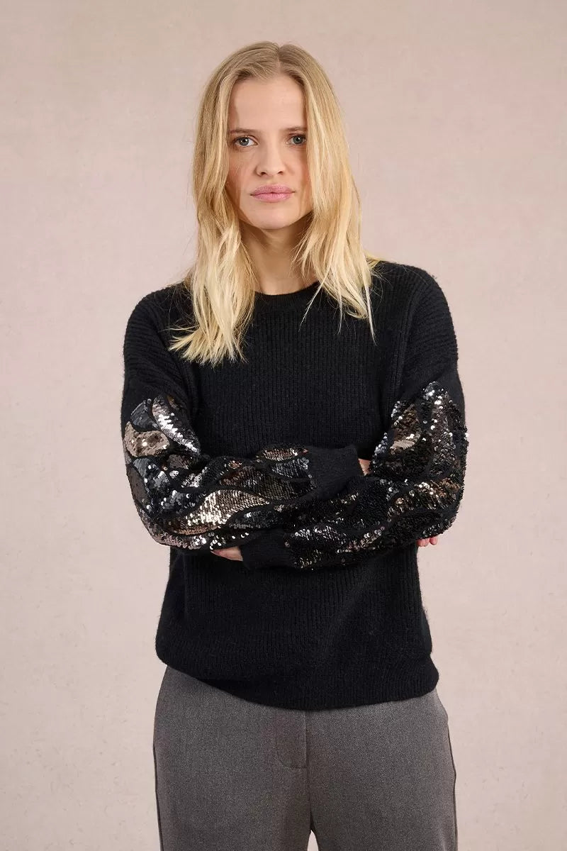 Model wearing Molly Bracken black jumper with sparkly sequin sleeves
