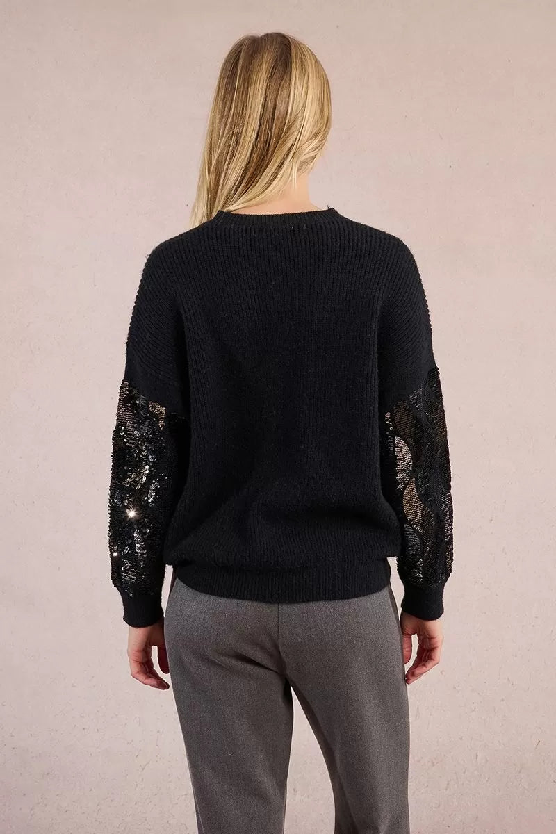 Back view of black knit jumper with statement silver sequin sleeves