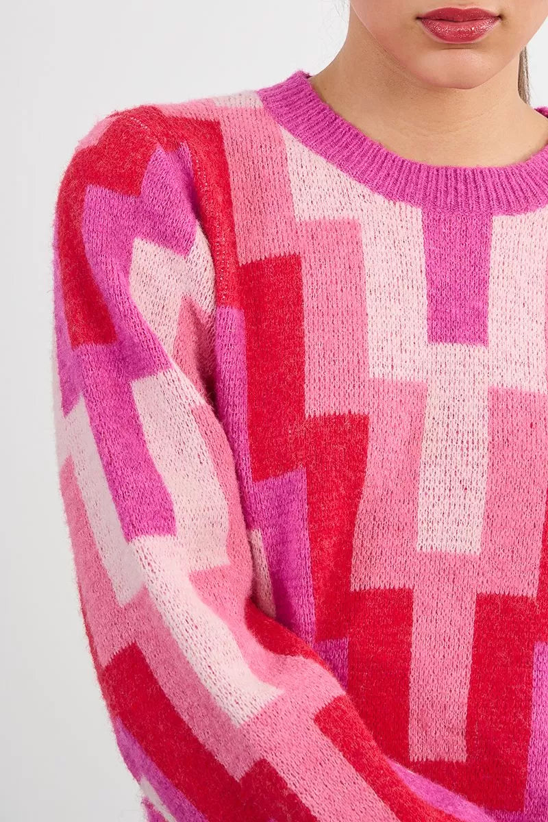 Close-up of Molly Bracken pink red geometric knit pattern
