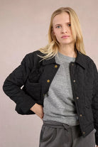 Molly Bracken quilted jacket styled with grey trousers, front angle
