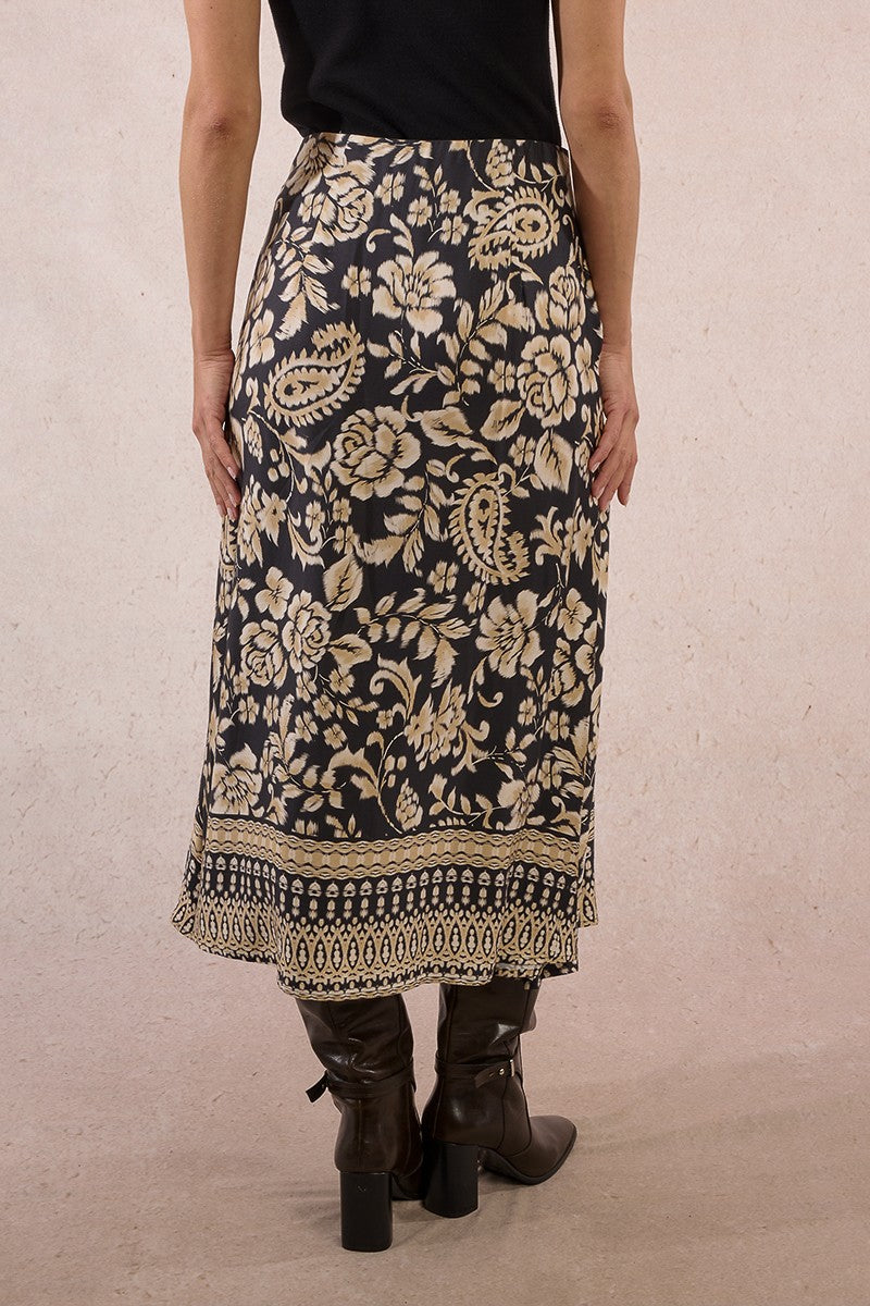 Back view of Molly Bracken long boho print skirt in black and beige with high waist and paisley border hem