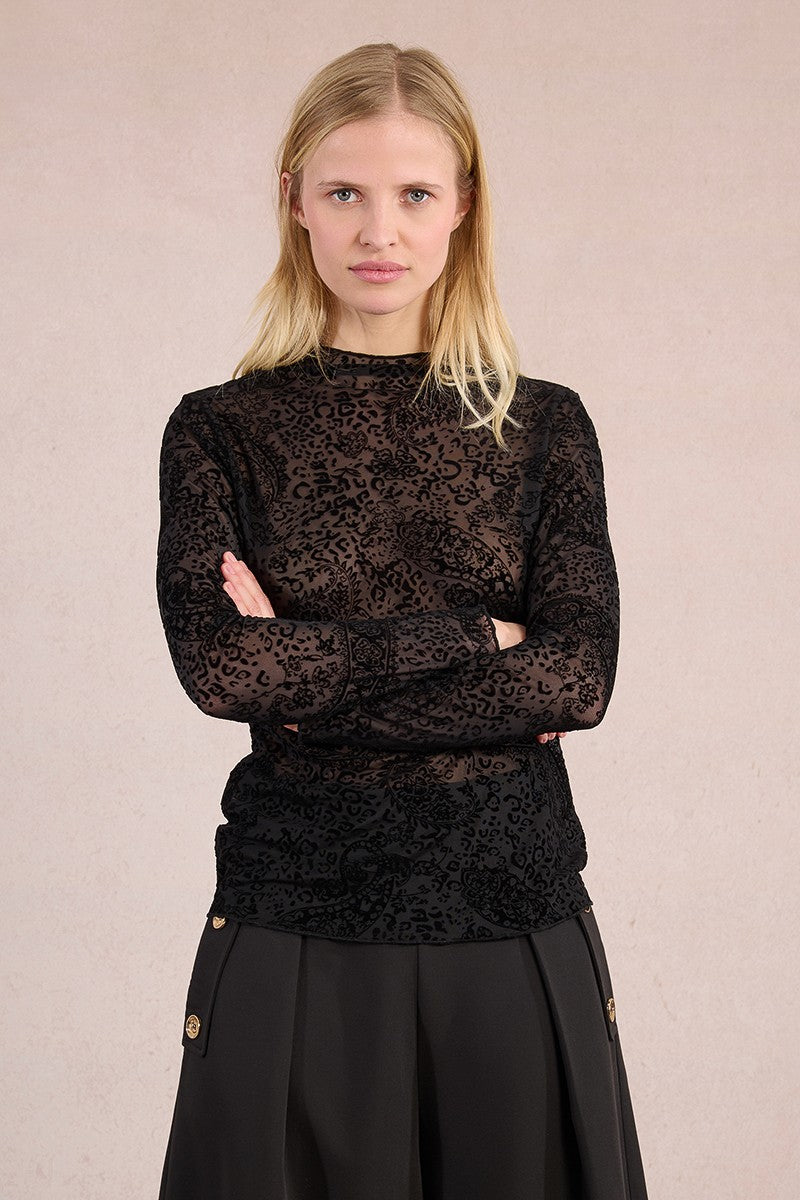 Model with arms crossed wearing Molly Bracken sheer paisley mesh top in black.