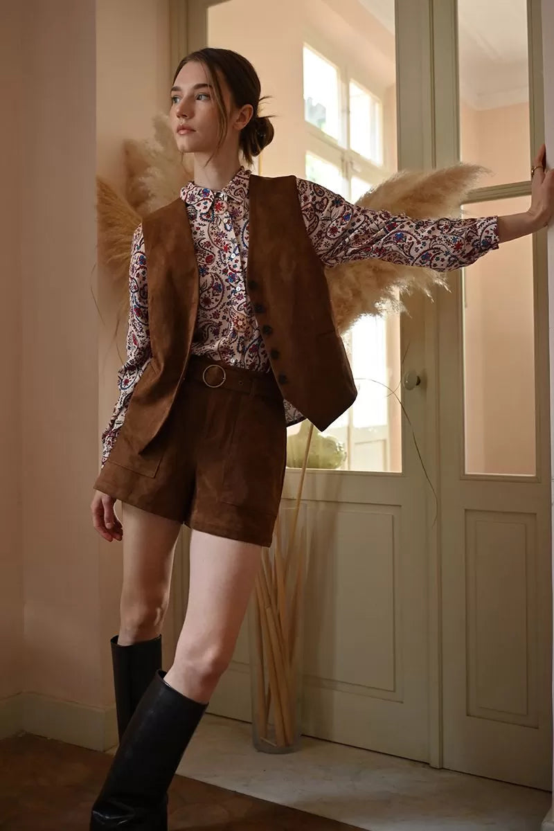 Model wearing Molly Bracken faux suede shorts in brown styled with patterned blouse and waistcoat.