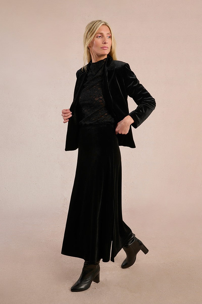 Model wearing Molly Bracken long black velvet skirt styled with lace blouse and blazer.