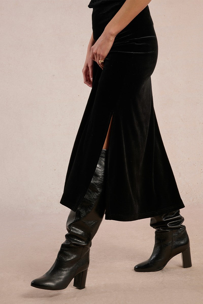 Close-up side view of Molly Bracken long velvet skirt in black showing slit detail.