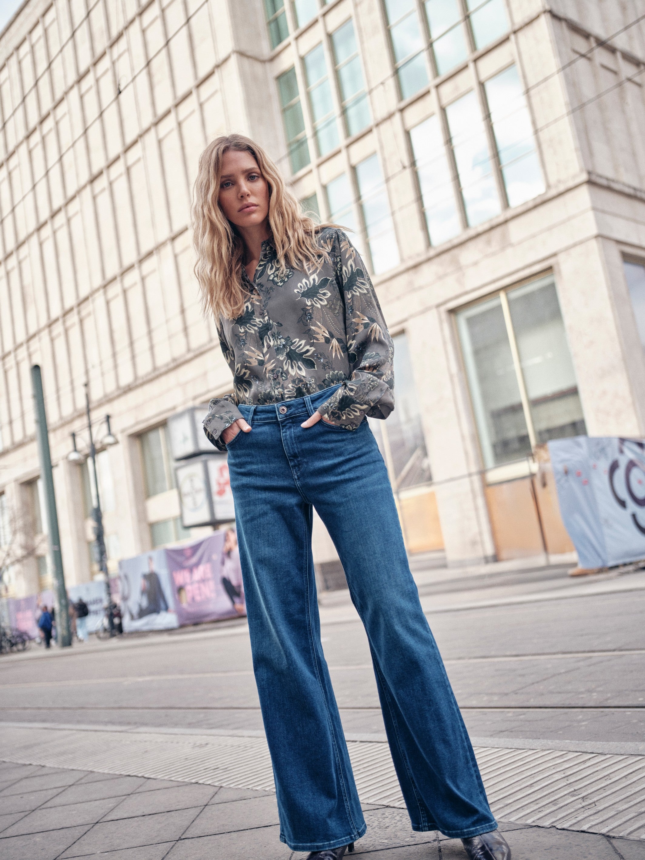 Model wearing Mos Mosh Dara Hera dark blue wide leg jeans with patterned blouse.