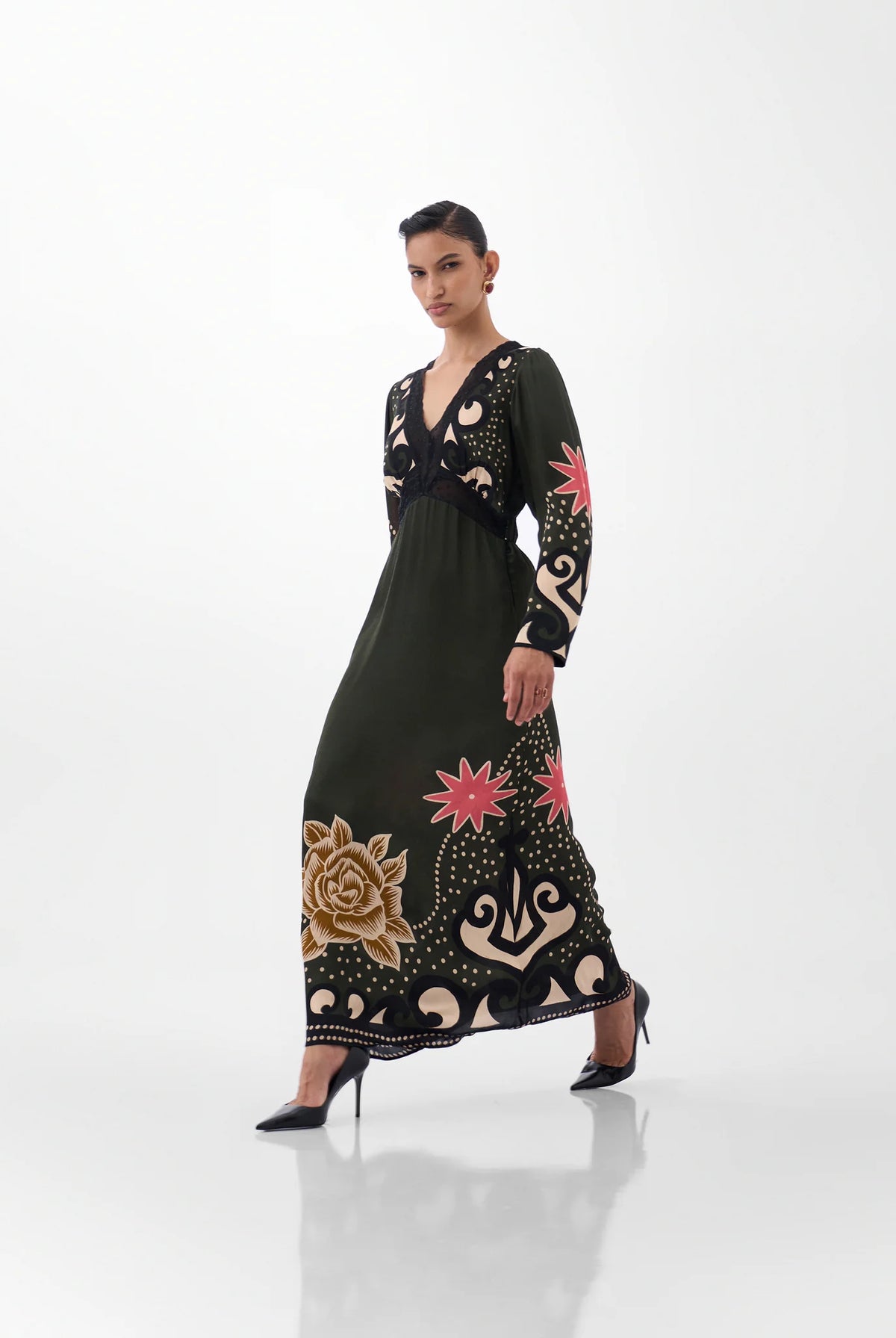 NOIB Aura green and black V-neck maxi dress with pink floral motifs and gold detailing – side model view.