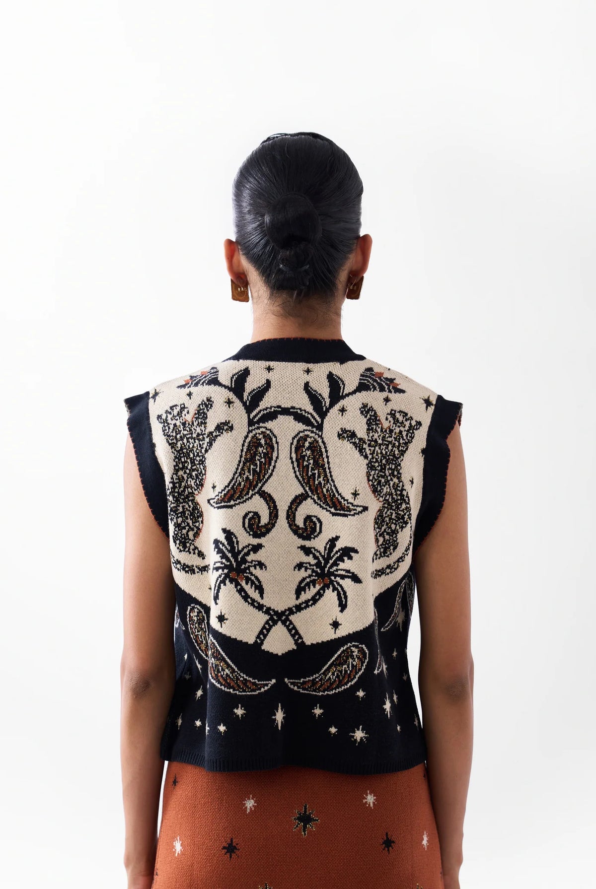 NOIB Lola Nocturnal Jungle sleeveless knitted vest showing palm trees and paisley motifs – back model view.