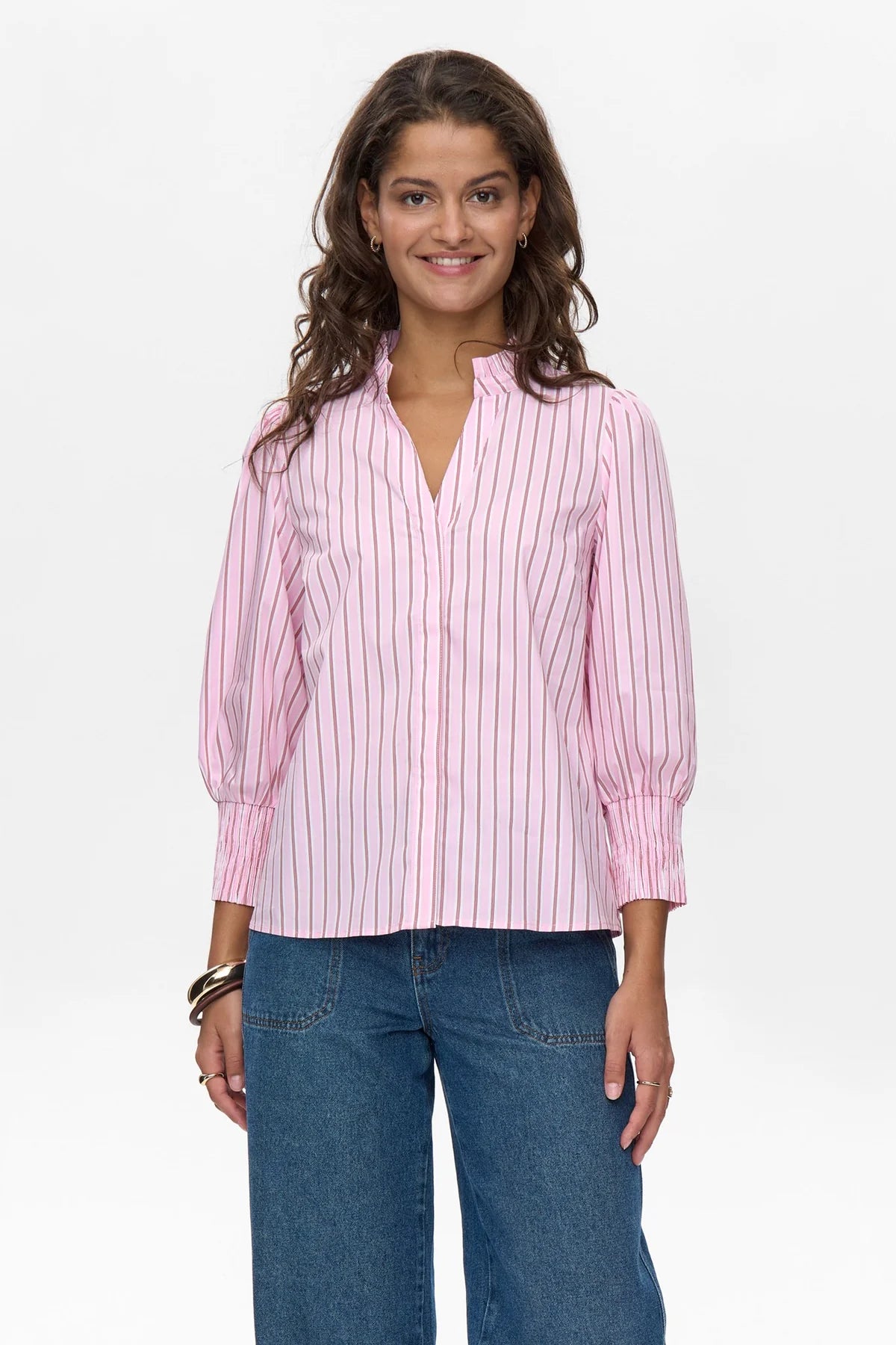 Model in pink pinstripe cotton blouse with puff sleeves and jeans