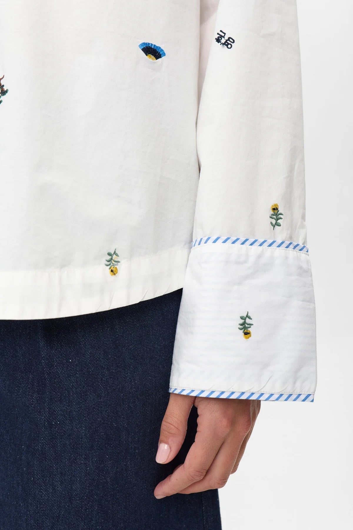 Mini floral and icon embroidery on Numph Nuchiro white cotton shirt sleeve.
