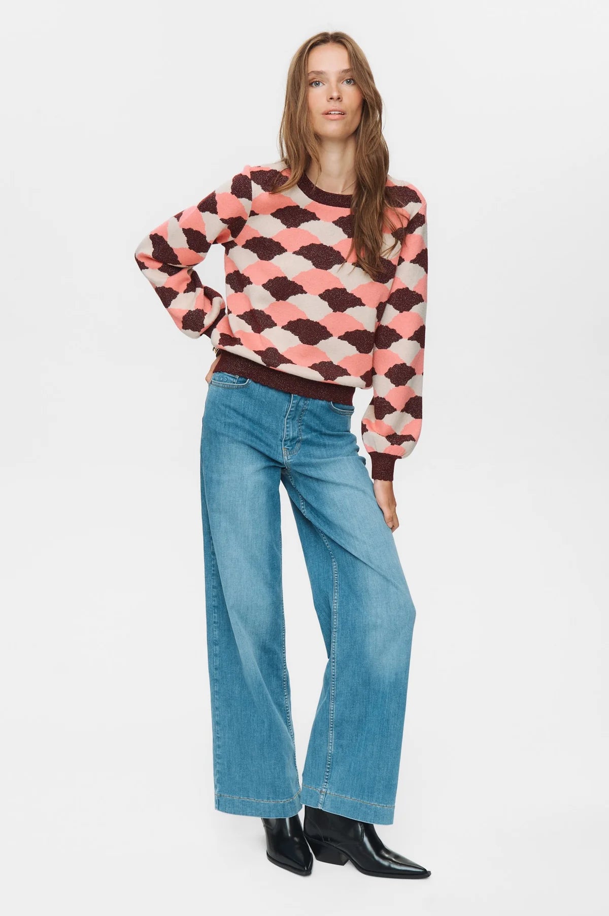 Model wearing Numph Nulila pink burgundy jumper with blue jeans for casual yet colourful outfit