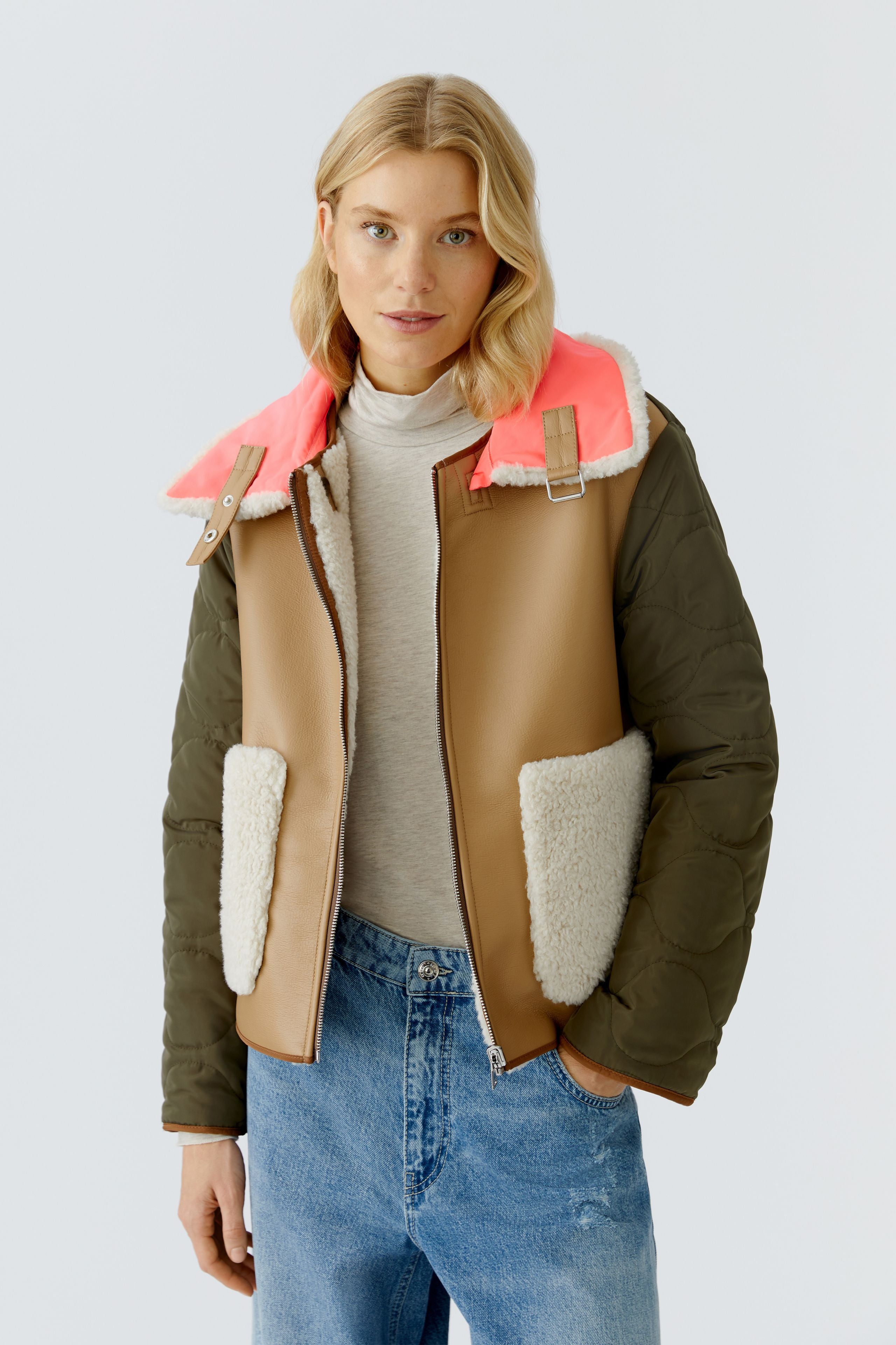 Oui reversible jacket — front view, tan faux-leather side with khaki quilted sleeves and neon collar tab.