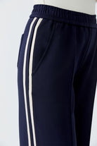 Detailed side angle of cream striped trim and structured waistband on navy trousers